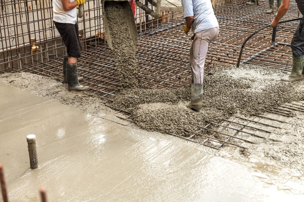 Pouring concrete into the construction of the house. Builders are pouring ready-mixed concrete