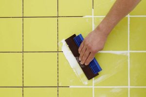hand-with-tool-tile-grouting