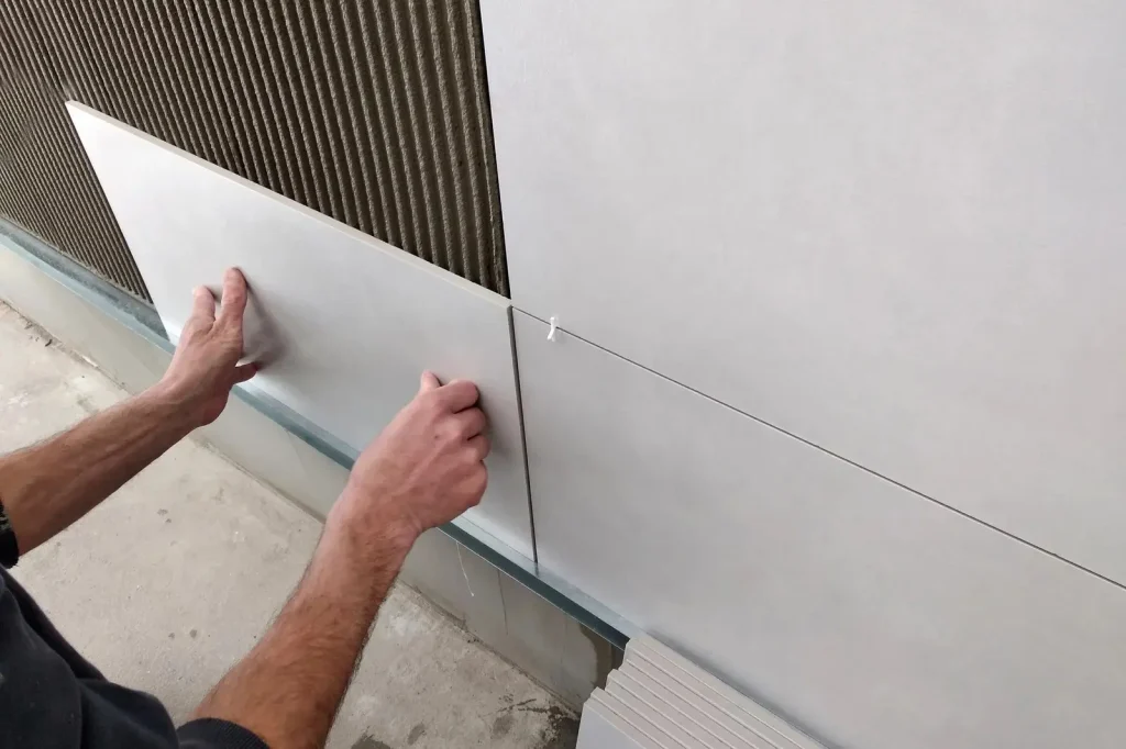 worker-hands-putting-ceramic-tiles-on-the-wall