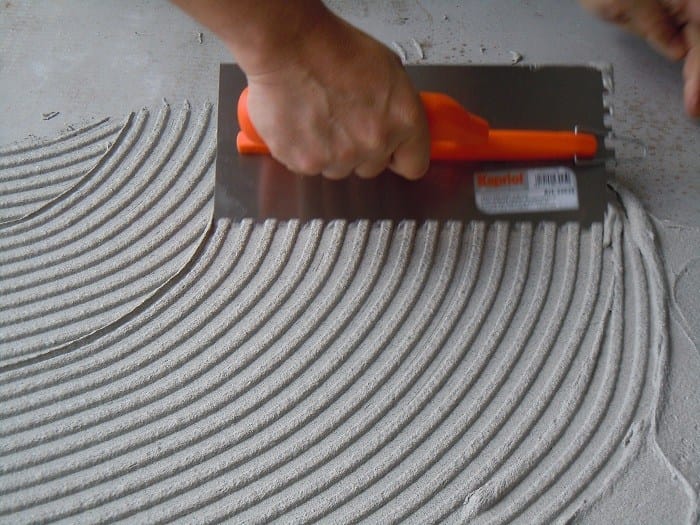 spreading-tile-adhesive-before-laying-tiles