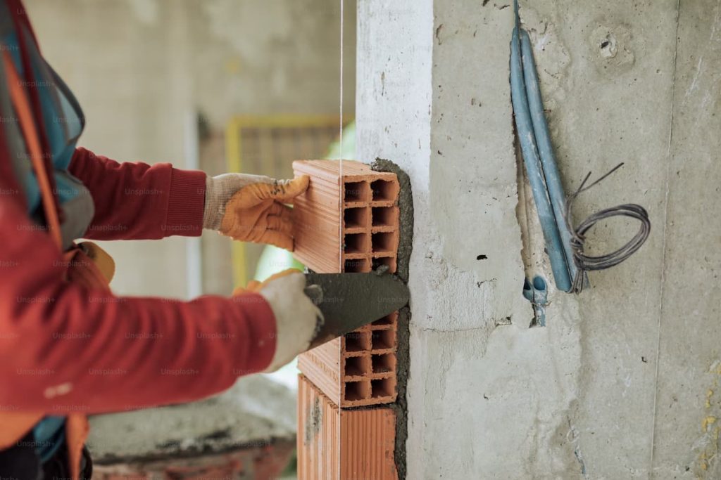 worker-laying-hollow-bricks-with-mortar