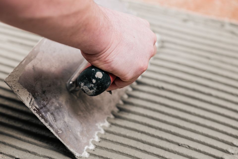 construction-worker-is-tiling-at-home