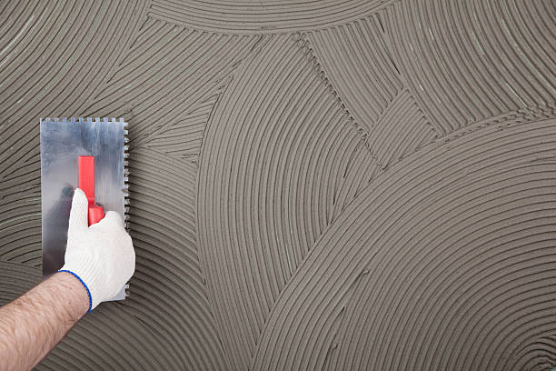 Hand of a construction worker applying tile adhesive